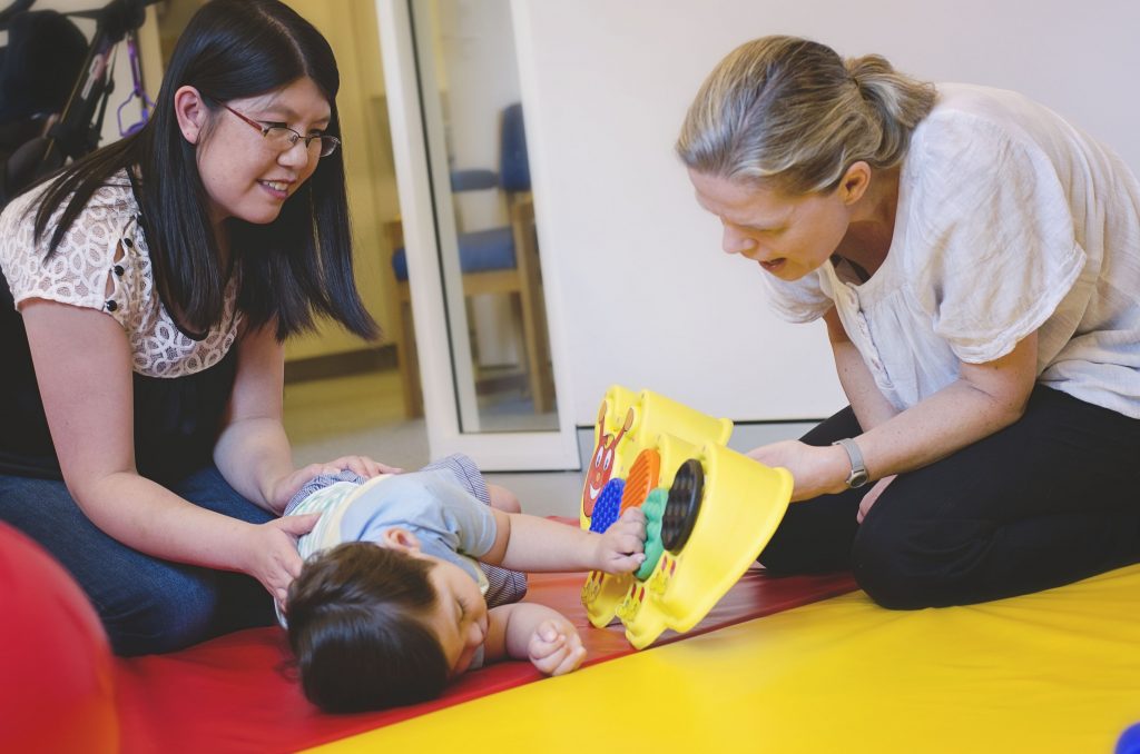 image of boy lying on mat during therapy with parent and therapist